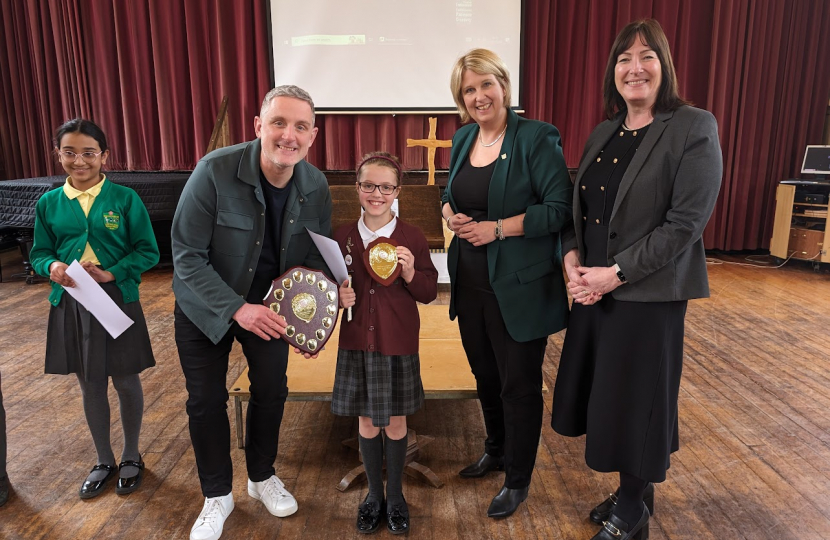Olivia being presented with her trophy. Katherine Fletcher, Nicola Moran and Graham Liver also in the picture and there is another child standing next to them holding a certificate.