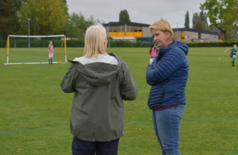 Katherine standing on a football pitch talking to another woman