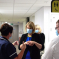 Katherine in medical setting talking to staff and wearing a medical mask