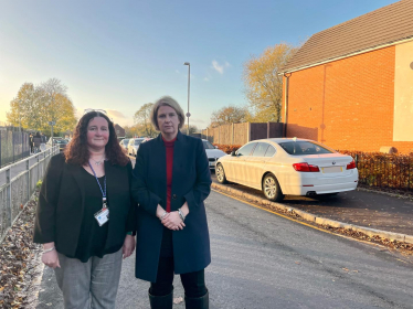 Katherine Fletcher and the headteacher of St. Mary's outside the school, bad parking visible
