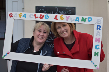Katherine Fletcher with Kelly, the manager of the RAFA Club. They are holding a fake picture frame around themselves with "RAF Club Leyland" written on it.