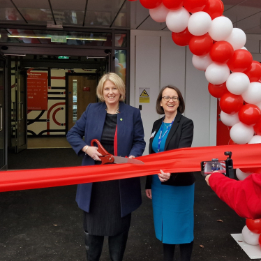 Katherine Fletcher outside the new building at Runshaw. She is stood with the Principal of the college, and has a large pair of scissors in her hand, ready to cut the ribbon.