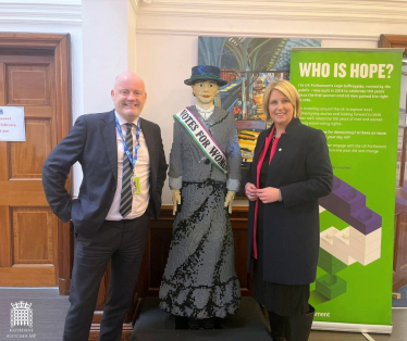 Katherine Fletcher stood with the vice principal of Cardinal Newman College and a Lego model of a suffragette.