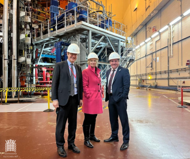 Katherine Fletcher with two others stood in front of industrial machinery