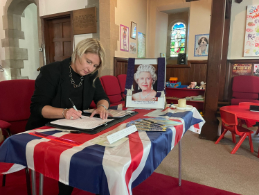 Katherine Fletcher signing a book of condolences.