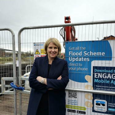 Katherine standing in front of flood scheme update sign in penwortham